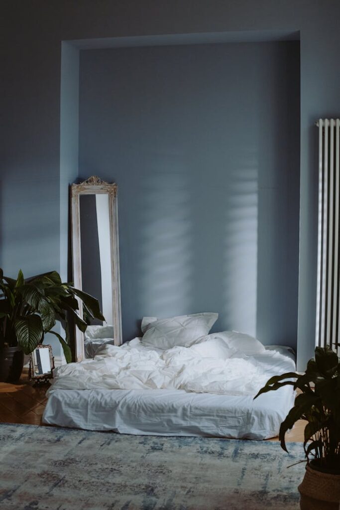 A serene and minimal bedroom interior with soft lighting and green plants, perfect for a peaceful atmosphere.